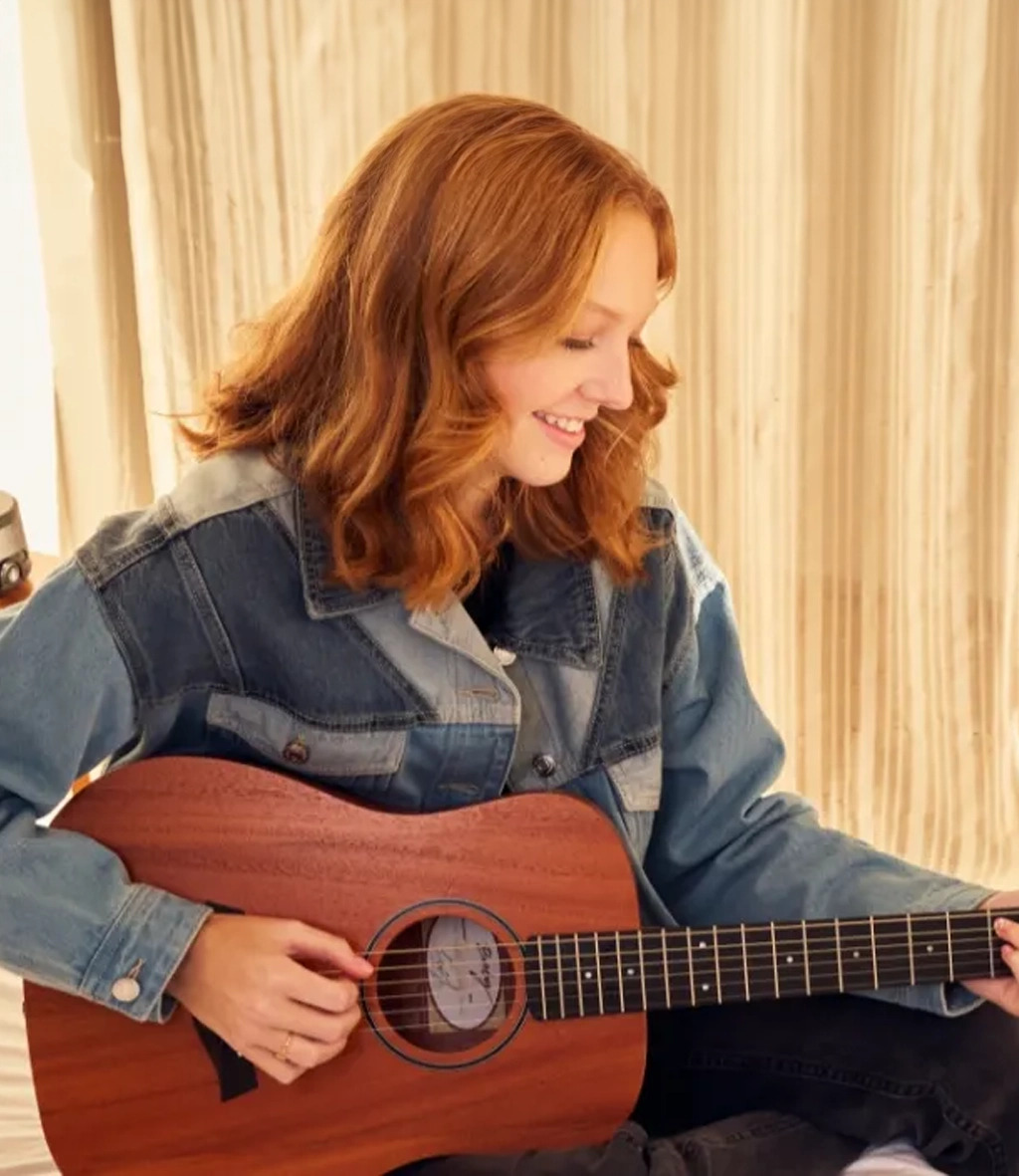 Girl playing baby taylor guitar wearing jean jacket