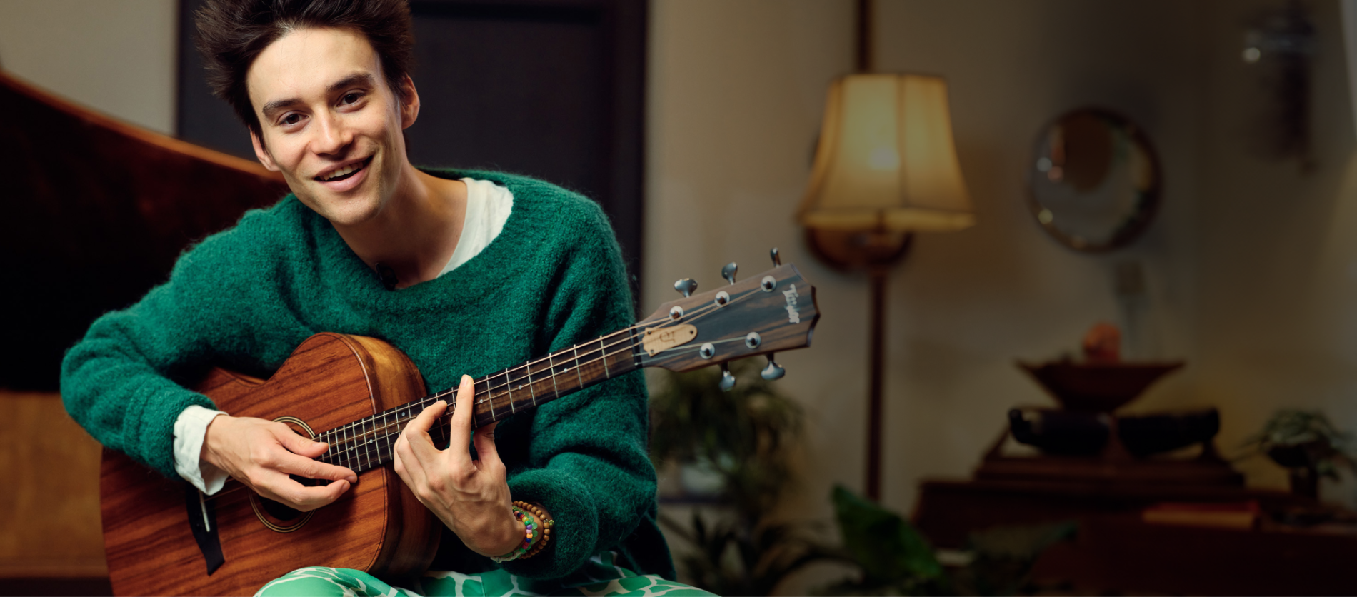 Jacob Collier holding a 5-string guitar
