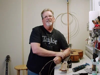 guitar tech standing by workbench changing guitar strings